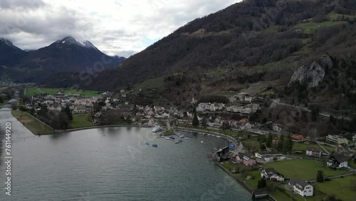 Community on lake shoreline with boats and hotels overlooking water in Walensee Switzerland photo