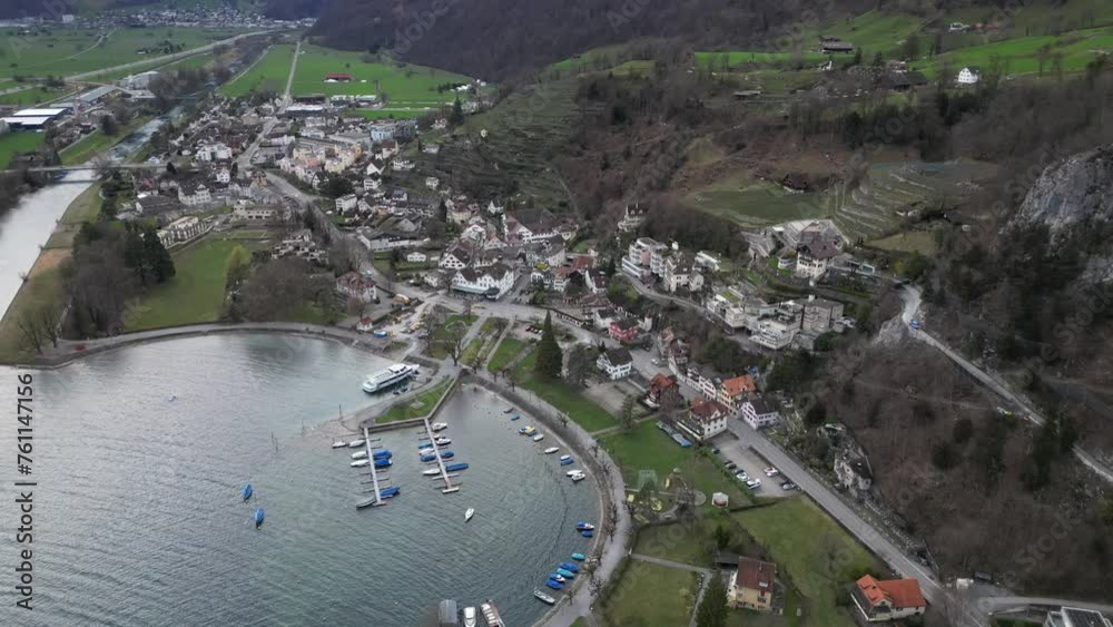 Dynamic aerial ascend establishes pier or dock with small boats to explore swiss lake Dynamic aerial ascend establishes pier or dock with small boats to explore swiss lake