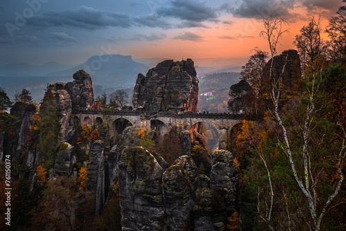 Saxon, Germany - The Bastei bridge with a sunny autumn sunset with colorful foliage and sky. Bastei is famous for the beautiful rock formation in Saxon Switzerland National Park near Dresden