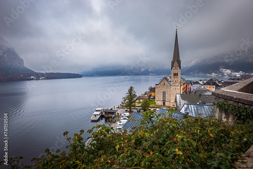 Hallstatt, Austria - The world famous Hallstatt, the Unesco protected lakeside town with Hallstatt Lutheran Church on a cold foggy day with snowy winter rooftops at Salzkammergut region