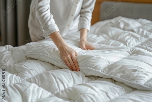 Woman is putting the bedding cover or mattress pad on the bed or putting off for cleaning process