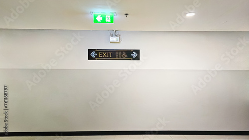 Public fire exit entrance with toilet sign. Empty public toilet corridor. Walkway to public restroom. Fire exit sign and walkway