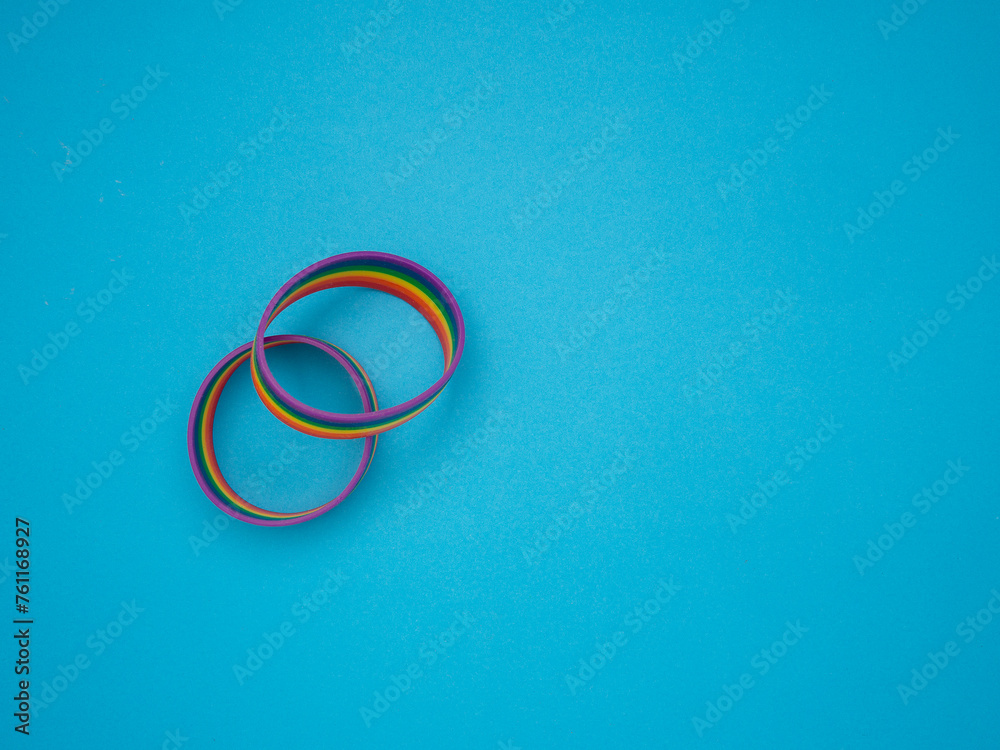 Rainbow patterned wristbands are on a blue background. Rainbow patterned wristbands are on a blue background.