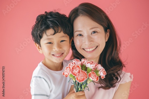 カーネーションの花束を持った、笑顔の子供とお母さん（母の日・mother's day・記念日） photo