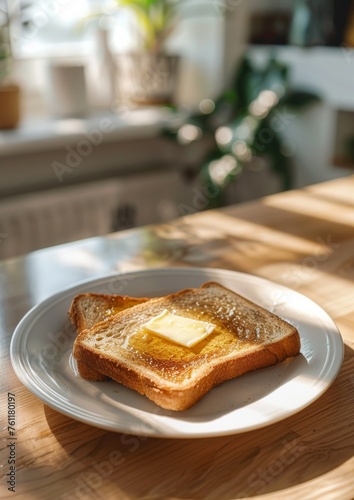 Toasted crispy toast with melted butter on a plate placed on the kitchen table.