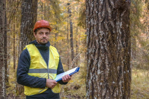 A forest engineer inspects a forest area. Real people work.