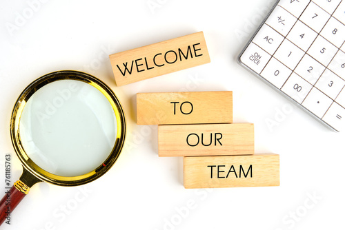 Concept words Welcome to our team on wooden blocks on a white background next to a calculator and a magnifying glass