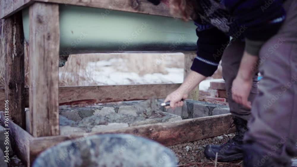 Man Laying Concrete Block And Putting Cement Using A Finishing Trowel. Diy Hot Tub. Close-up Man Laying Concrete Block And Putting Cement Using A Finishing Trowel. Diy Hot Tub. Close-up