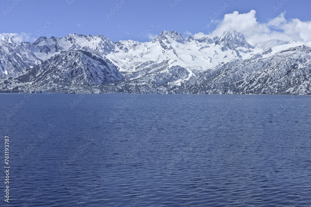 Mountain Lake under Blue Sky in Winter Landscape with Snowy Peaks and Forest