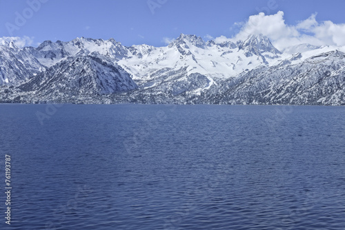 Mountain Lake under Blue Sky in Winter Landscape with Snowy Peaks and Forest