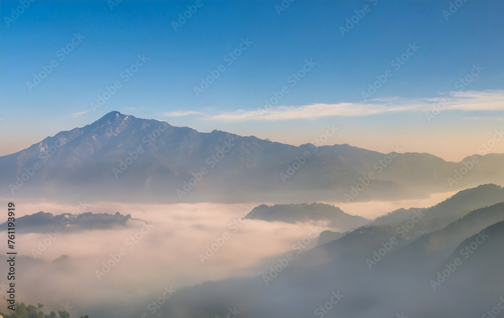Mountain peaks pierce through fog as the sun rises, painting the sky with vibrant colors