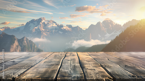 A wooden deck overlooking a mountain range with a clear blue sky. The view is serene and peaceful, with the sun shining brightly on the mountains. The wooden deck is a perfect spot to relax photo