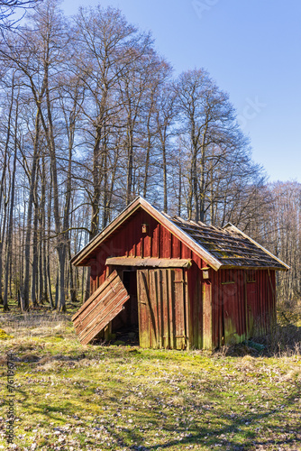 Old red wooden shed with hanging doors in the countryside © Lars Johansson
