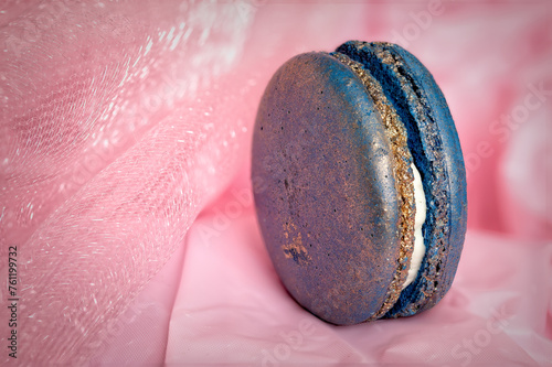 Blue macaroon with golden dust on pink background
