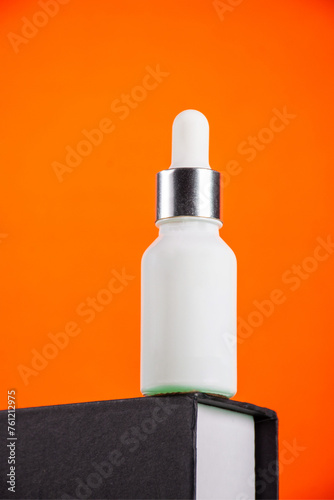 Plastic white tube for cream or lotion. Skin care or sunscreen cosmetic with stylish props on orange background.