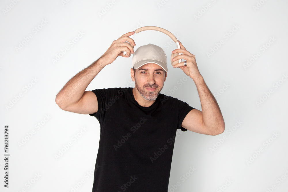 Chico colocándose cascos para escuchar música. Hombre mirando a cámara escuchando música. Colocarse auriculares.