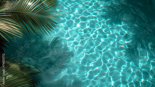 Tropical palm leaves in swimming pool with sun reflections, background