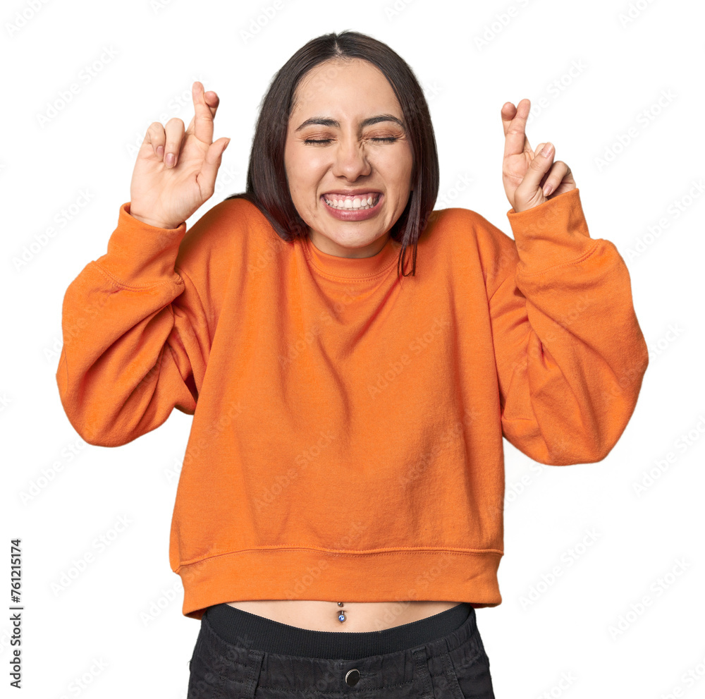 Modern young Caucasian woman portrait on studio background crossing fingers for having luck - obrazy, fototapety, plakaty 