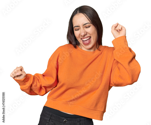 Modern young Caucasian woman portrait on studio background dancing and having fun.