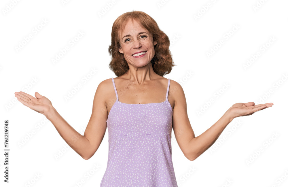Redhead mid-aged Caucasian woman in studio makes scale with arms, feels happy and confident. Redhead mid-aged Caucasian woman in studio makes scale with arms, feels happy and confident.