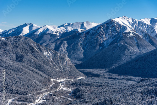 Beautiful landscape of the Arkhyz ski resort with mountains, snow, forest on sunny winter day. Caucasus Mountains, Russia.