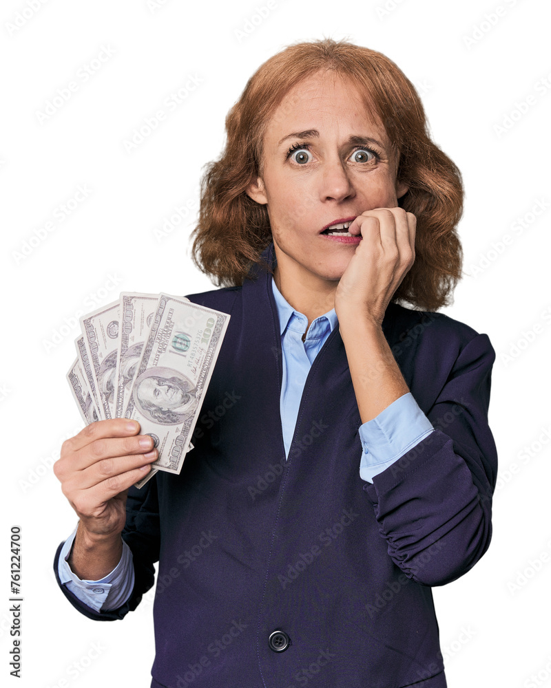 Mid-aged Caucasian with dollars in studio biting fingernails, nervous and very anxious. Mid-aged Caucasian with dollars in studio biting fingernails, nervous and very anxious.