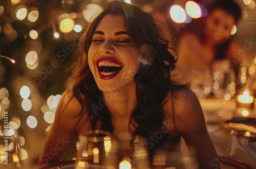 Photo of a beautiful woman laughing at a table during dinner in a restaurant, holding food with her hand and showing it to friends, wearing a black dress and diamond necklace