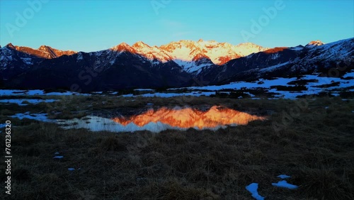 Sunset over the Pyrenees mountains with the reflection of the peaks in the water of the lake High quality 4k footage photo