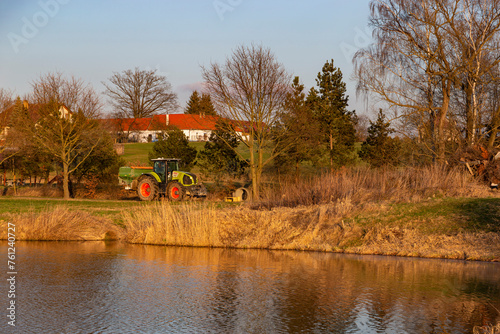 Tractor on the shore of the pond.
