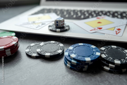  casino chips and playing cards on laptop notebook. Poker game online concept