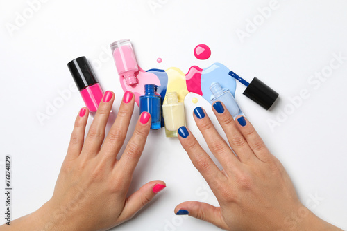 Multicolored open nail polishes on a white background
