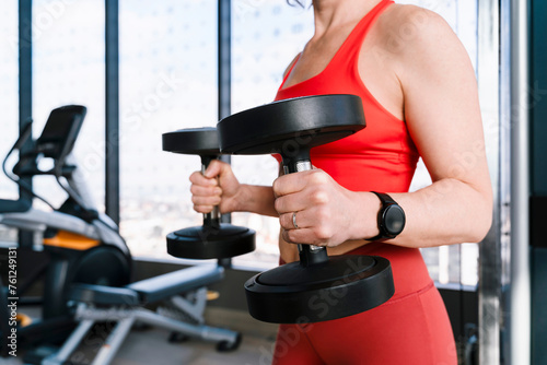 Mature woman exercising with dumbbells in gym photo