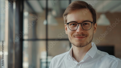 Young businessman with a contemplative look in modern office setting.