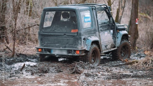 SUV drives forward on off road, splashing mud to sides. Car participating in off-road racing drivings dirty road and goes forward. High quality 4k footage