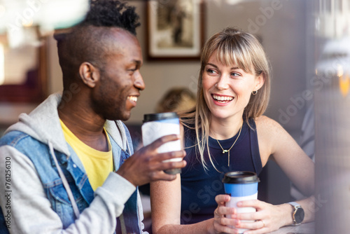 Smiling blond woman having coffee with friend at cafe photo