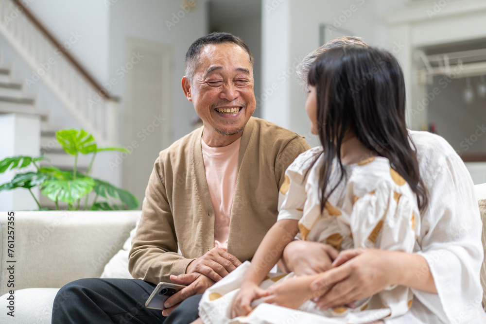 Obraz premium Portrait of happy love asian grandfather with grandmother and asian little cute girl enjoy relax at home.Young girl with their laughing grandparents smiling together.Family and togetherness