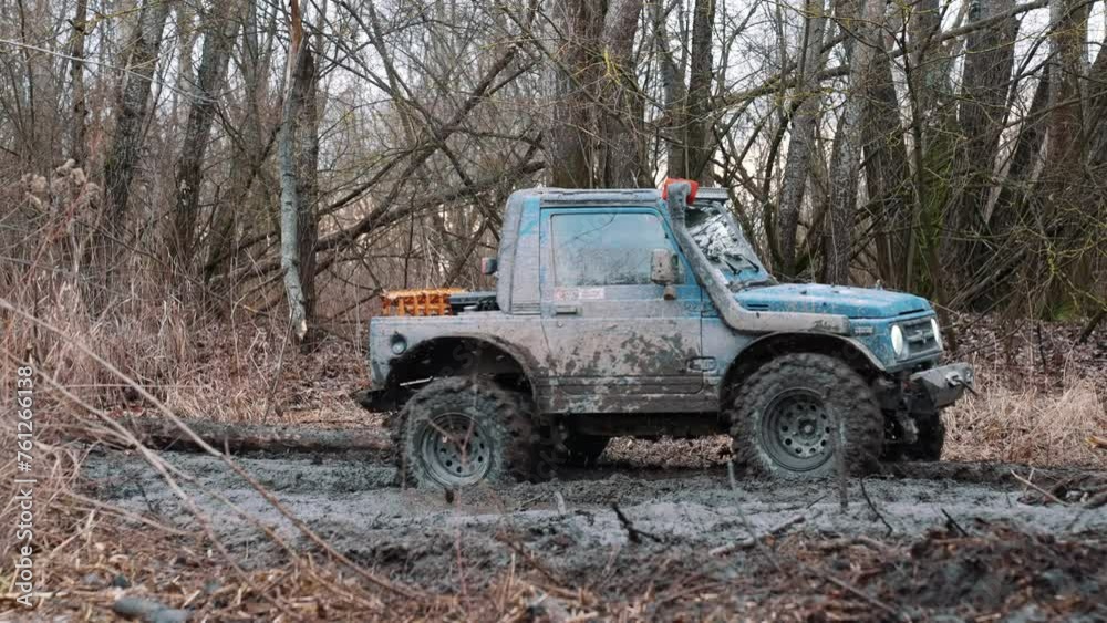 Competition of off-road cars. Dirty offroad car with fall forest on background on sunny autumn day. SUV covered with mud on path covered with leaves. High quality 4k footage Competition of off-road cars. Dirty offroad car with fall forest on background on sunny autumn day. SUV covered with mud on path covered with leaves. High quality 4k footage