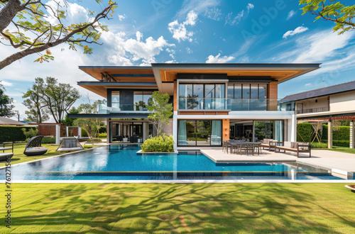 Modern tropical villa with pool and garden, panoramic view of the front yard, interior design of a modern living room in white color, bright lighting, blue sky © Kien