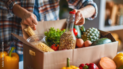 a person packing a donation box with food items