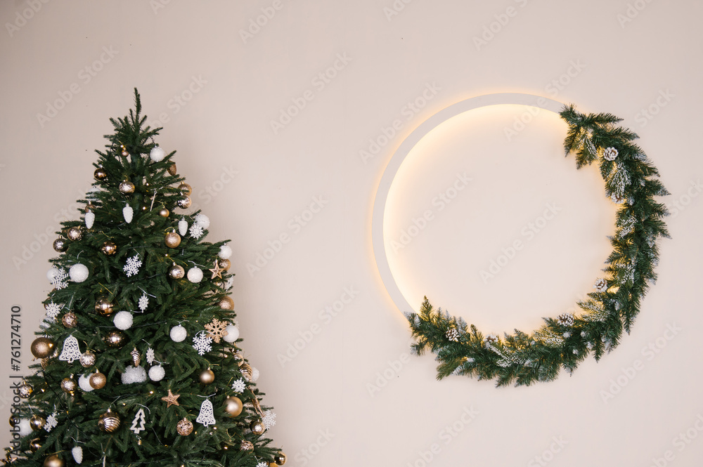 Stylish Christmas wreath with backlight on a white wall background, New Year decor, empty space for text