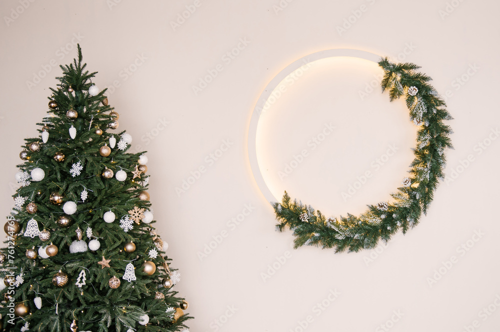 Stylish Christmas wreath with backlight on a white wall background, New Year decor, empty space for text