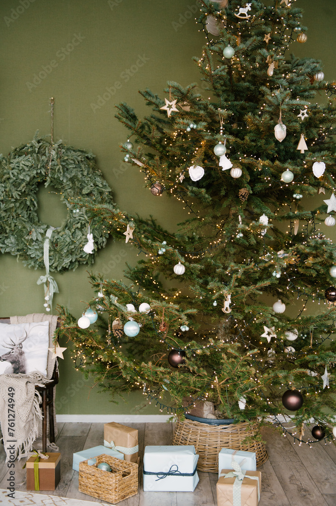 Beautiful New Year decor in a stylish interior with a Christmas tree, wreath and gifts