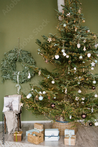 Beautiful New Year decor in a stylish interior with a Christmas tree, wreath and gifts