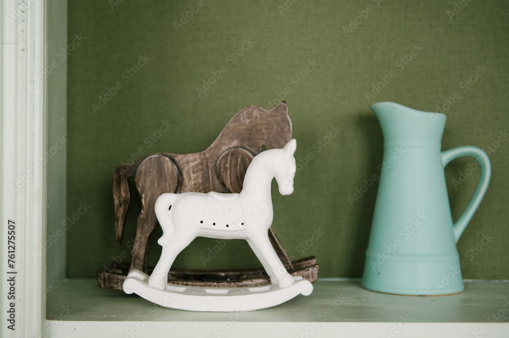 Beautiful interior of the room with horses and a jug on the shelf