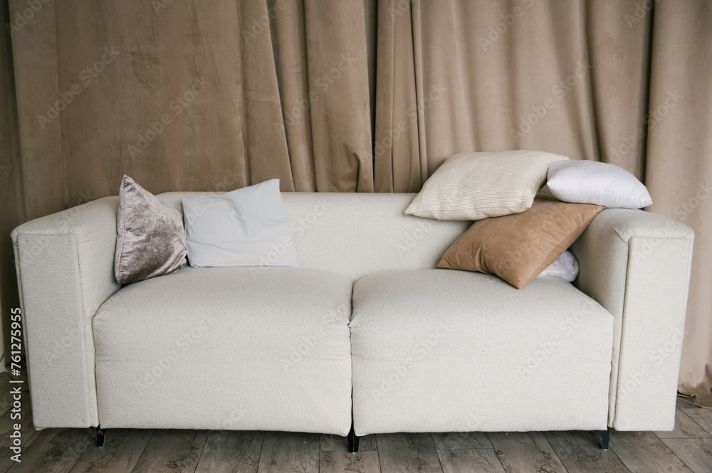 Beautiful stylish modern interior with a bright sofa, curtains and pillows