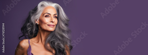 Elegant, elderly, chic latino, Spain woman with gray long hair and perfect skin, purple background, banner.