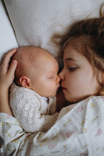 Foto Portrait of big sister cuddling newborn, little baby
