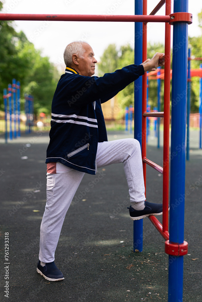 Fototapeta premium Sports grandfather doing fitness outdoors in park