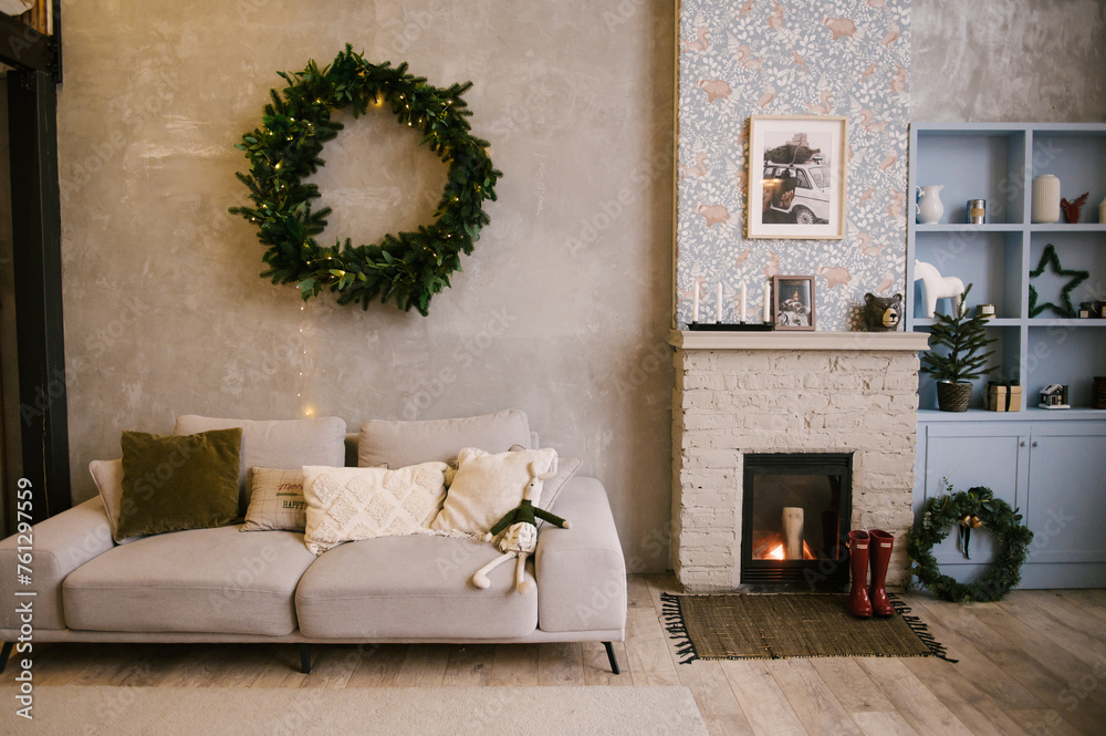 Interior design of the living room of the house with a sofa and a fireplace decorated for the new year