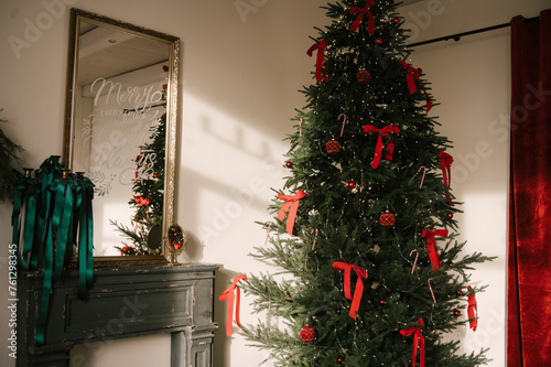 Obraz na płótnie Beautiful New Year decor, the Christmas tree is decorated with red bows in the stylish interior of the living room w salonie